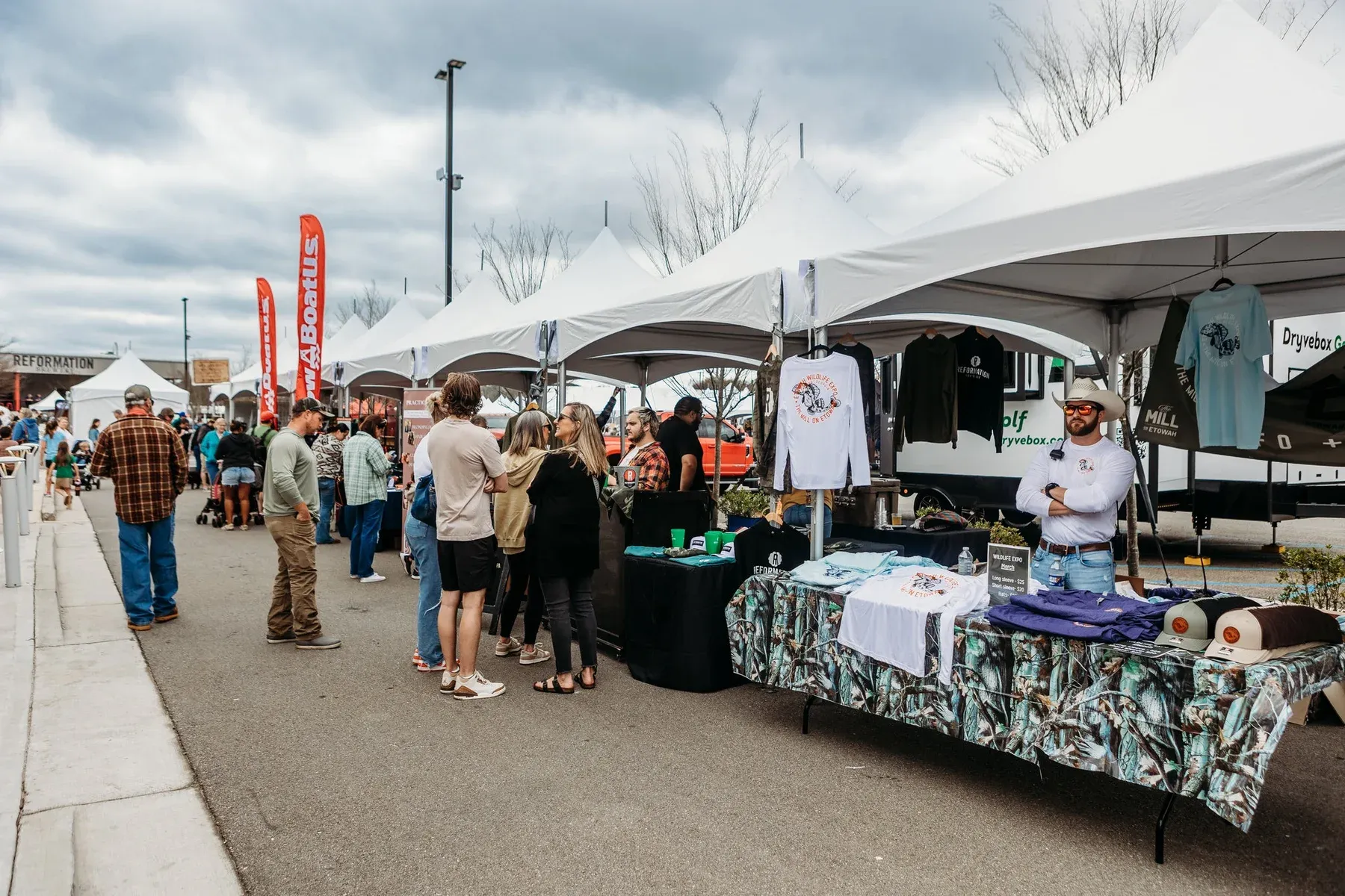Guests browsing stalls beneath white event tents
