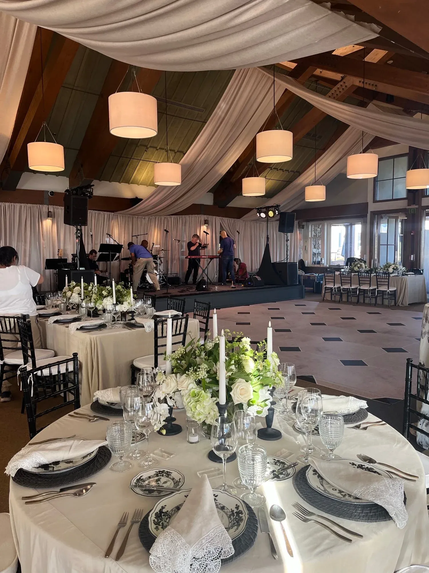 Indoor reception with round dining tables and dark chairs