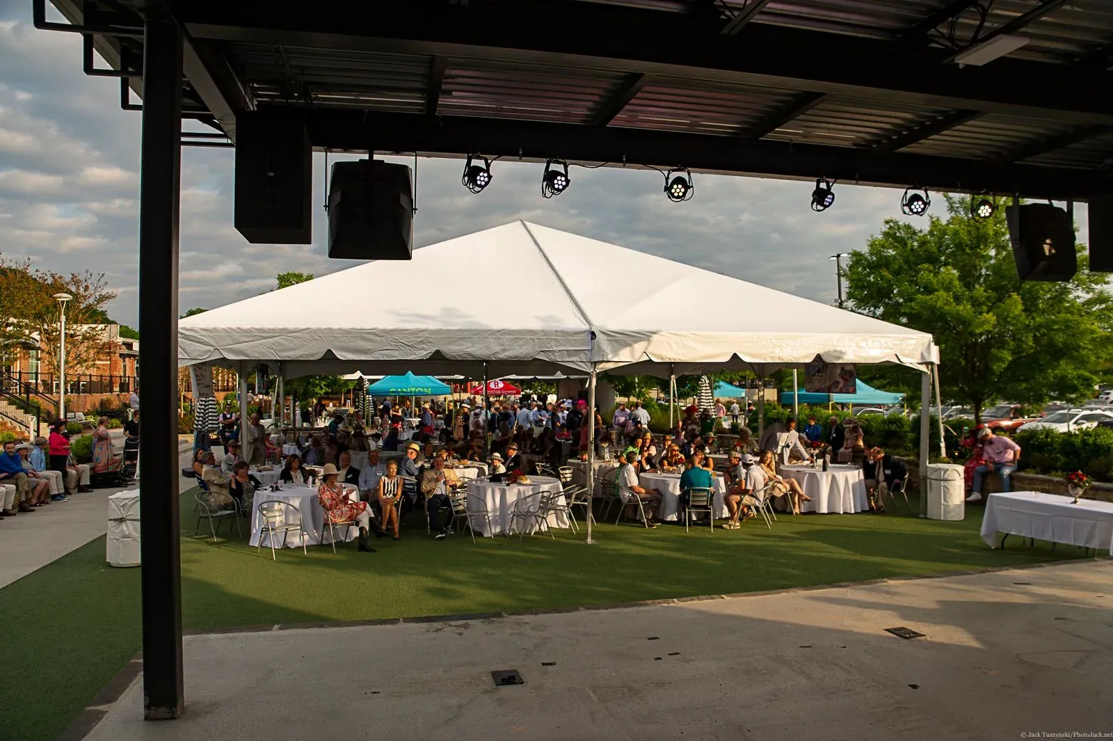 Guests gathered under a large white outdoor canopy