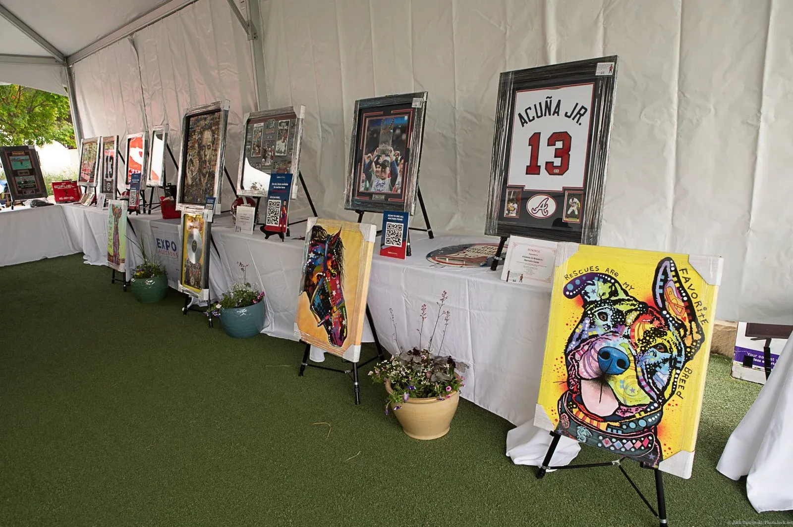 Paintings and serving tables inside a white tent