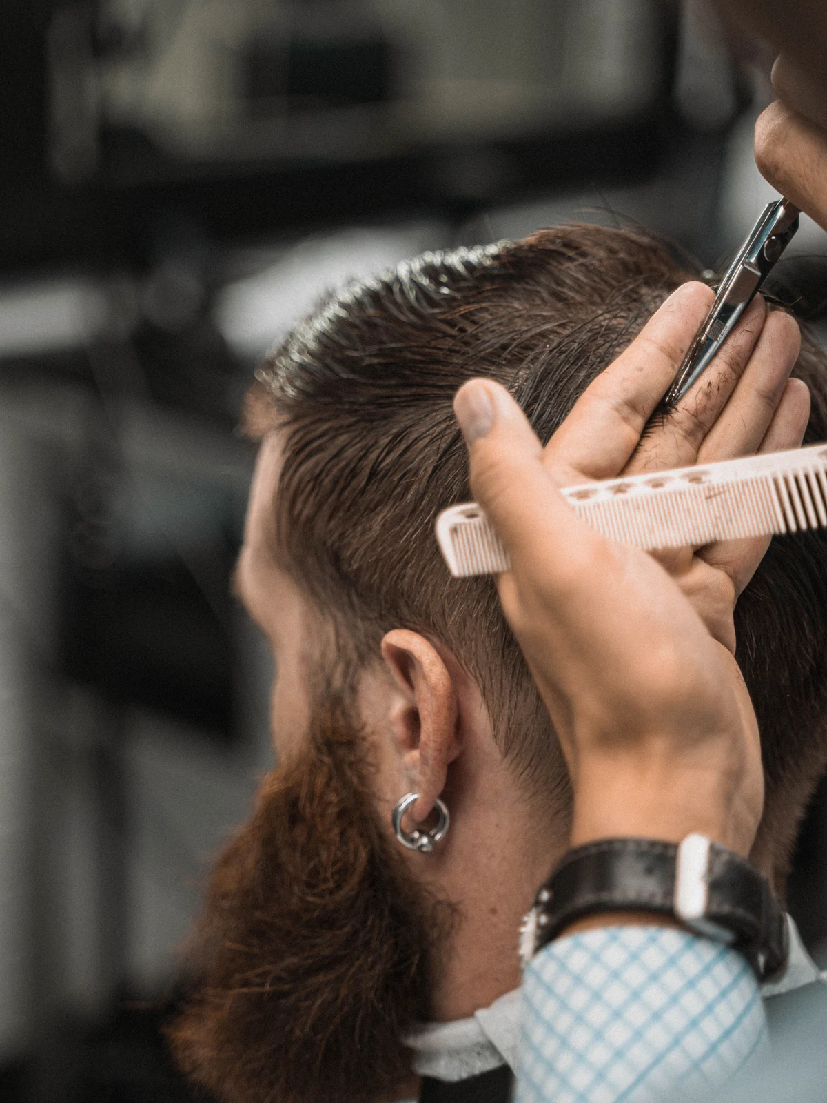 Stock photograph of a barber refining a short haircut with scissors