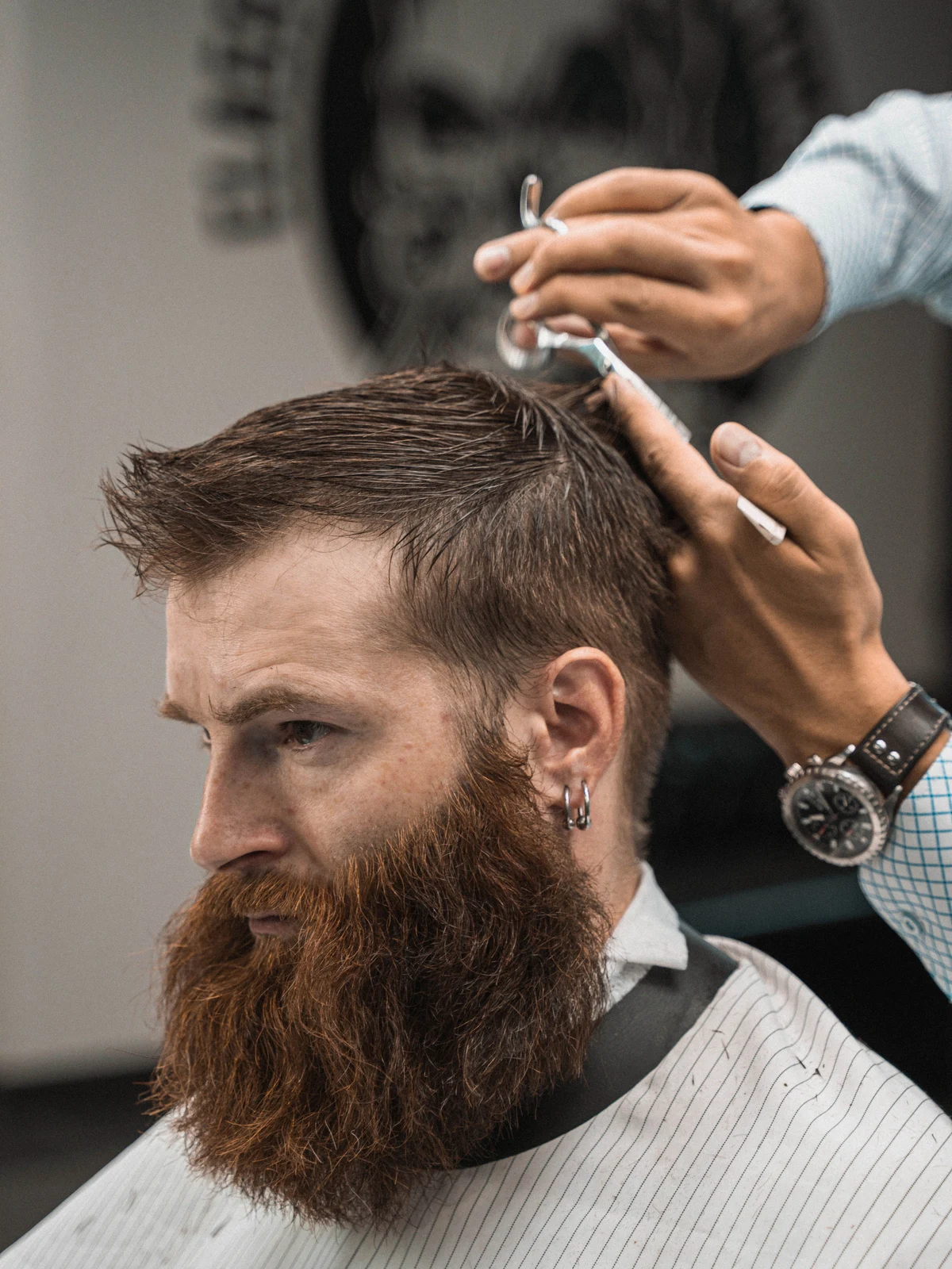 Stock photograph of a bearded client having his hair styled in profile