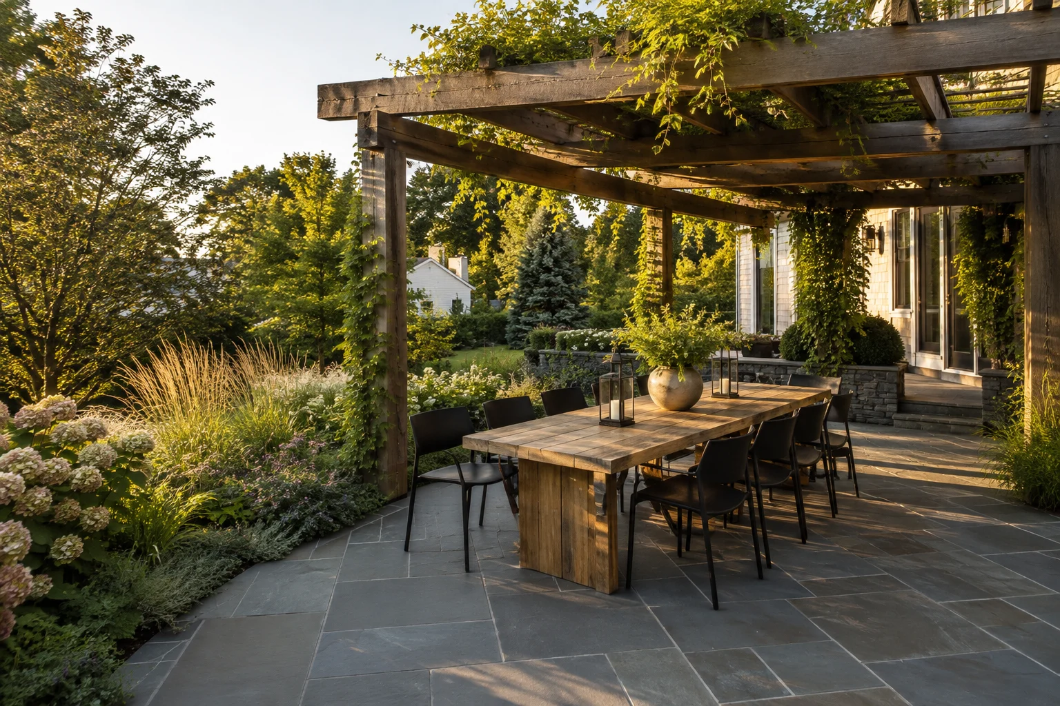 Cedar pergola shading an outdoor dining terrace with bluestone paving — landscape design