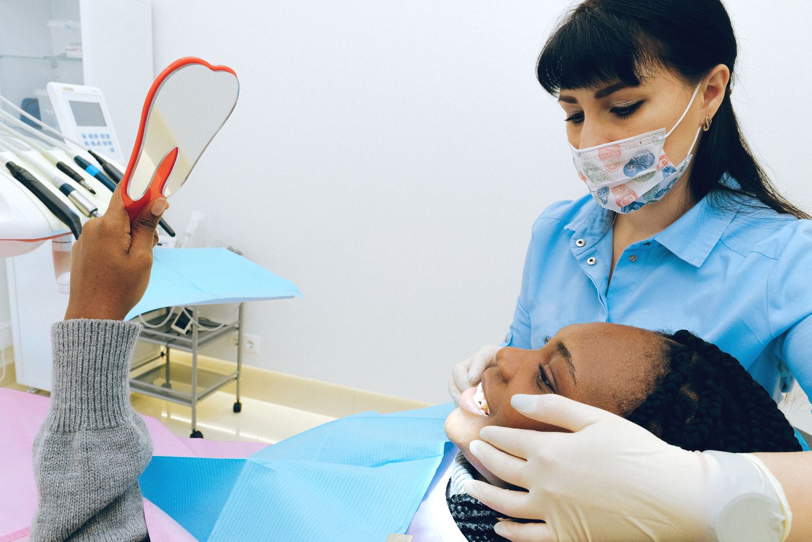 A patient looking at her smile with her dentist